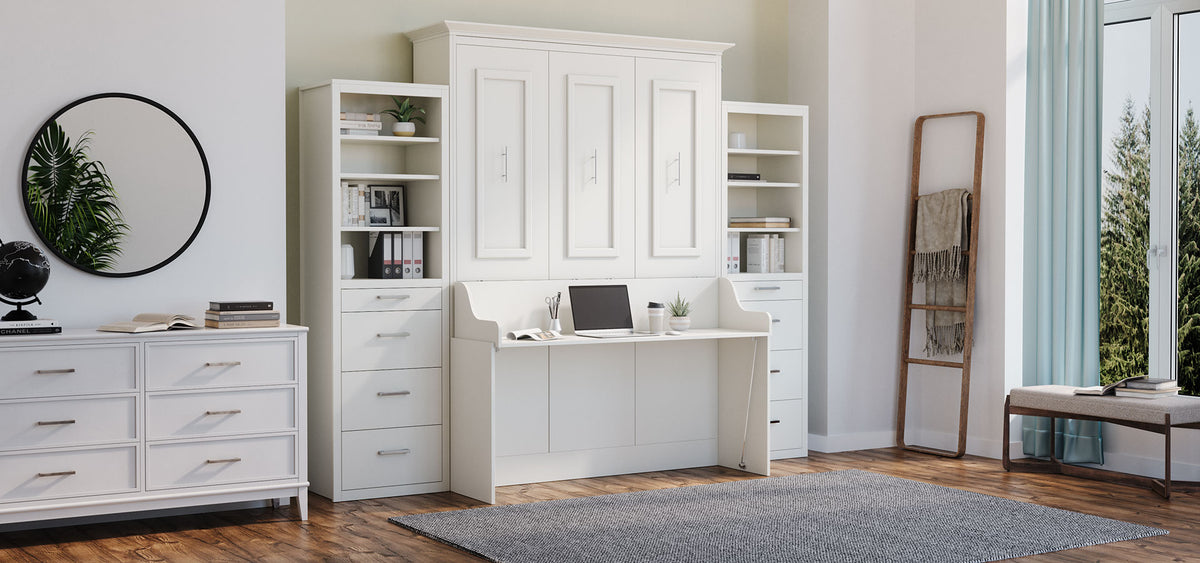 A white Murphy Bed with desk and storage towers is set in a bright room,  and includes a dresser, a mirror, and a floor ladder.