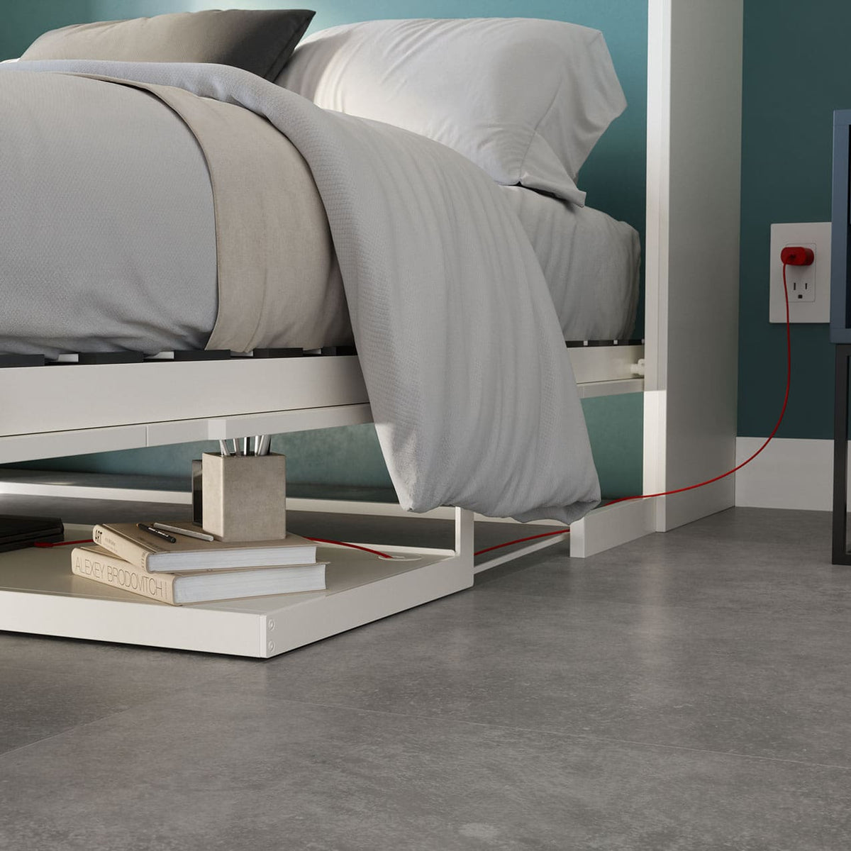 Murphy Bed with gray bedding in a room with a concrete floor and teal walls. Lit escamotable