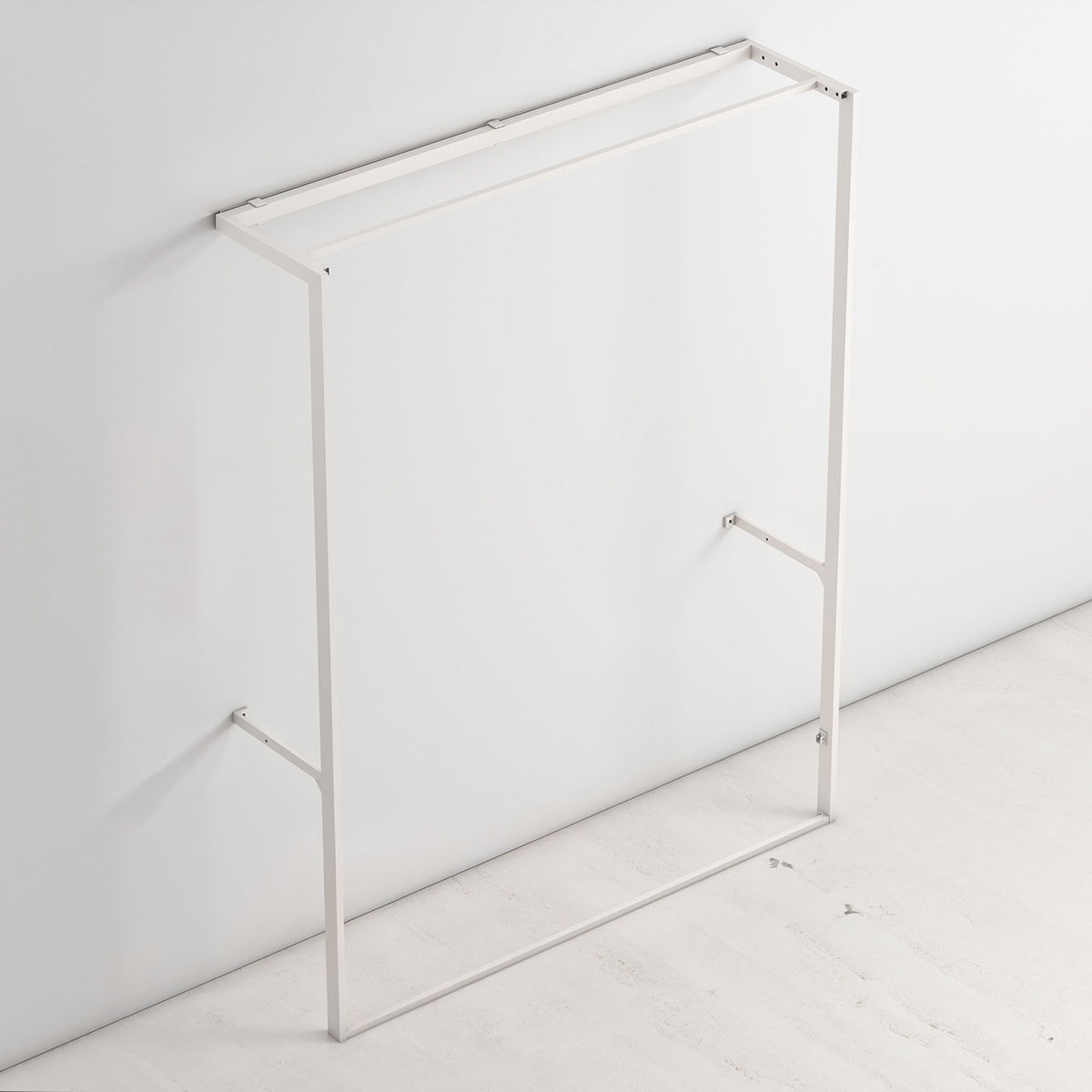 Metal Murphy bed frame attached to a light gray wall and sitting on a marble floor. 