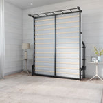 room with a black metal liftable bed up against the wall with two small side tables and a carpet